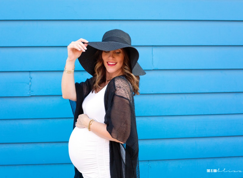 Maternity photoshoot with hat in front of blue building - 33 week Bumpdate - This is our Bliss