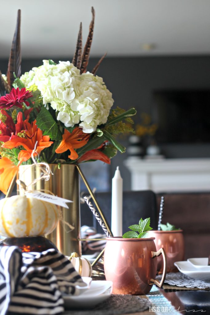 Fall centerpiece with feathers and fall colored flowers - How to bring fall into your home - Simple Fall decorating ideas - Here are 17 ways to bring Fall into your Home this year! Click for all the details! -his is our Bliss