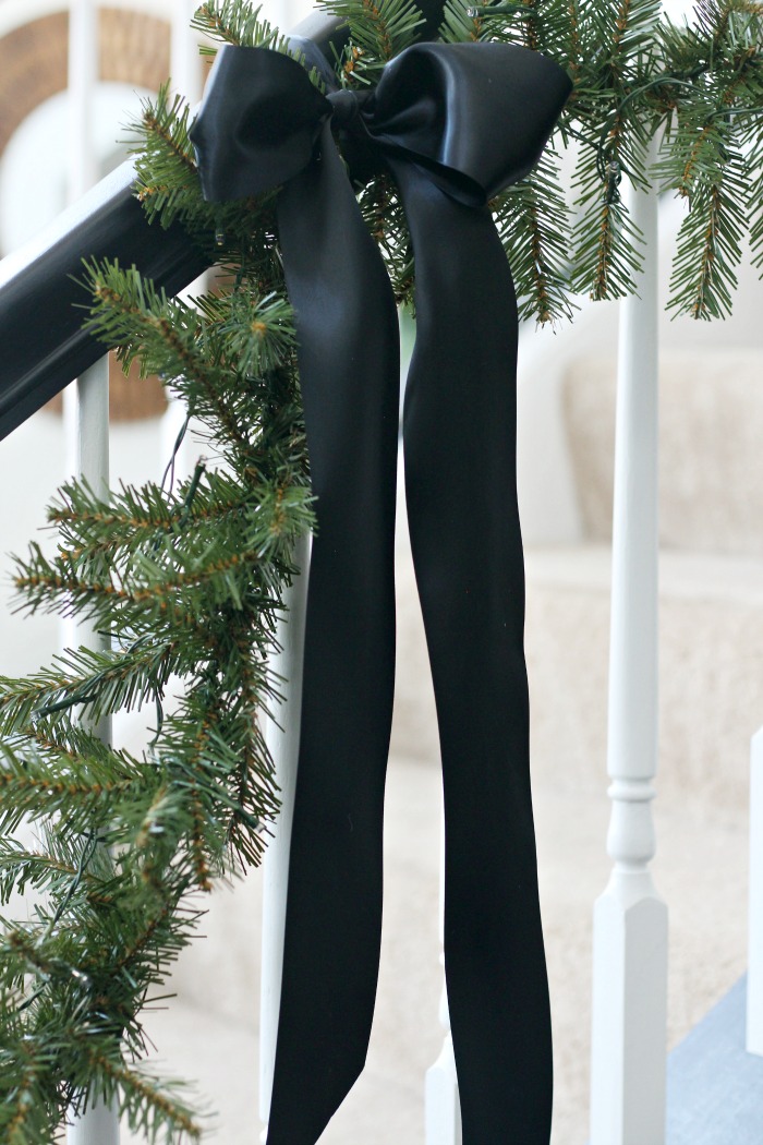 Black satin ribbon bows on the staircase garland - Simple and elegant Christmas decor - This is our Bliss