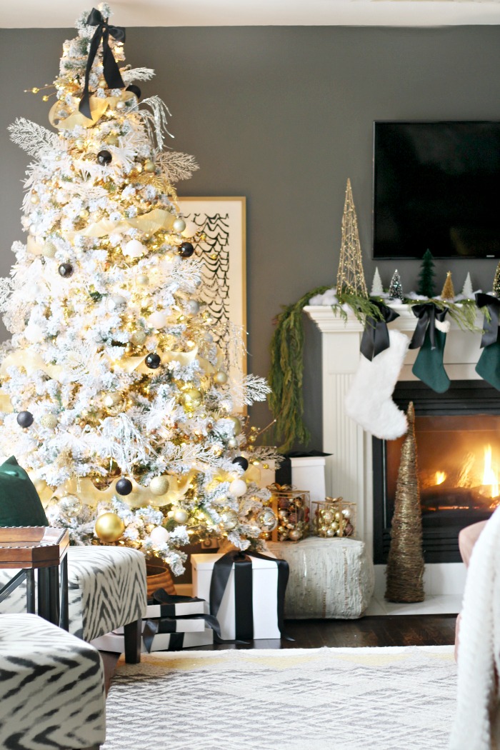 Simple and elegant Christmas Family Room - flocked tree with black white and metallic ornaments - pops of green on the mantel stockings - This is our Bliss