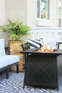fire pit table on cozy back deck with Trex composite decking - leopard print outdoor rug - This is our Bliss
